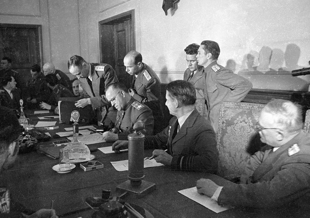 У име Немачке акт је потписао фелдмаршал Вилхелм Кајтел, у име Совјетског Савеза маршал Георгиј Жуков, а у име западних савезника британски ваздухопловни генерал Артур Тедер.